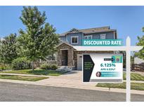 Charming two-story home featuring stone accents, a covered porch, landscaped yard and a promotional sign at 14881 Rider Pl, Parker, CO 80134