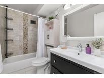 Bright bathroom featuring tiled walls, updated vanity, and shower-tub combination at 6940 E Girard Ave # 210, Denver, CO 80224