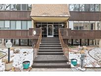 Inviting building entrance with steps leading to a glass door and a covered entryway for residents and guests at 6940 E Girard Ave # 210, Denver, CO 80224