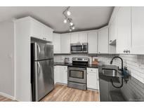 Updated kitchen with white cabinets, stainless steel appliances, and granite countertops at 6940 E Girard Ave # 210, Denver, CO 80224