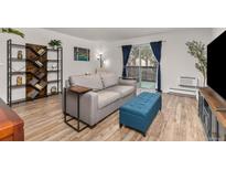 Bright living room features a sliding glass door with balcony access, modern furniture, and a stylish bookshelf at 6940 E Girard Ave # 210, Denver, CO 80224