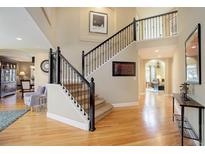 Spacious foyer with hardwood floors, staircase with iron railings, and soaring ceilings at 10914 W Coco Pl, Littleton, CO 80127