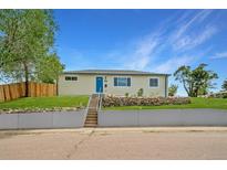 Charming home featuring a well-maintained lawn, rock garden, and a bright blue front door at 4640 W Ellsworth Ave, Denver, CO 80219