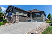 Charming exterior elevation featuring a two-car garage, stone accents, and a well-maintained front yard at 3375 New Haven Cir, Castle Rock, CO 80109