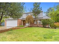 Charming two-story home with brick and siding exterior, landscaped yard, and attached garage at 6602 S Vance St, Littleton, CO 80123