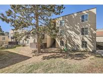 A tan three-story apartment building with stairs and a large tree in the front at 9995 E Harvard Ave # 246, Denver, CO 80231