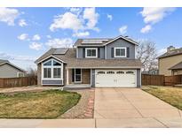 Charming two-story home with a well-manicured lawn and a spacious two-car garage, complemented by solar panels at 9392 Crestmore Way, Highlands Ranch, CO 80126