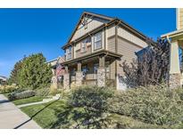 Charming two-story home featuring a welcoming front porch and well-maintained landscaping at 21851 E Tallkid Ave, Parker, CO 80138