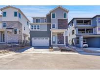Modern two-story home featuring mixed siding, a two-car garage, and a covered front porch at 11902 Octave Ave, Parker, CO 80134