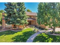 Charming brick home featuring lush landscaping and a curved walkway leading to the front entrance at 8136 S Glencoe Ct, Centennial, CO 80122