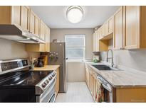 Bright kitchen features light wood cabinets, stainless steel appliances, and a window with natural light at 1111 Maxwell Ave # 228, Boulder, CO 80304
