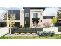 Modern two-story home boasting stone and black paneling, manicured landscaping, and a horizontal black fence at 140 S Glencoe St, Denver, CO 80246