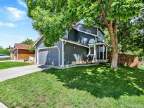 Charming two-story home with a well-maintained lawn and a large shade tree at 453 Arden Cir, Highlands Ranch, CO 80126