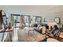 Bright living room with expansive windows, hardwood floors, and stylish contemporary furniture at 1050 N Corona St # 304, Denver, CO 80218