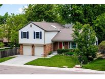 Charming two-story home featuring a brick facade, neutral siding, and a well-manicured lawn at 9502 W Hialeah Pl, Littleton, CO 80123