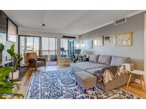 Cozy living room features a comfortable sectional sofa, balcony access and cityscape views at 800 N Pearl St # 1207, Denver, CO 80203