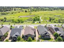 Stunning aerial view of houses with lush green space, trails, and distant windmill at 24028 E Caleb Pl, Aurora, CO 80016