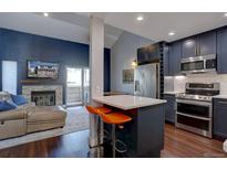 Open-concept living room with modern kitchen, fireplace, and sliding doors to the backyard at 8354 S Everett Way # C, Littleton, CO 80128