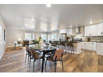 Open concept kitchen boasts modern white cabinets, stainless steel appliances, and a large island at 3225 N Olive St, Denver, CO 80207