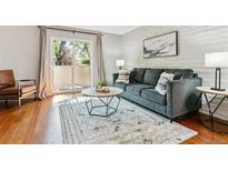 Bright living room features hardwood floors, a comfortable sofa, a sliding glass door, and stylish decor at 1060 S Parker Rd # 25, Denver, CO 80231
