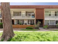 Charming condo building with brown accents, black metal railings, and a well-maintained lawn at 10185 W 25Th Ave # 33, Lakewood, CO 80215