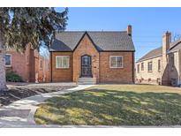 Charming brick home with a well-manicured lawn and inviting walkway on a sunny day at 1467 Clermont St, Denver, CO 80220