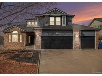 Charming two-story home features a brick and siding exterior with a two-car garage and well-maintained landscaping at 4431 W Jamison Pl, Littleton, CO 80128