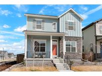 Charming two-story home featuring stone accents, a welcoming front porch, and a well-manicured yard at 21209 E 62Nd Ave, Aurora, CO 80019