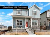 Charming two-story home featuring a cozy front porch, stone accents, and a well-manicured lawn at 21209 E 62Nd Ave, Aurora, CO 80019