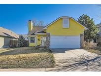 Charming yellow single-Gathering home featuring a chimney and attached garage on a sunny day at 4386 Sable St, Denver, CO 80239