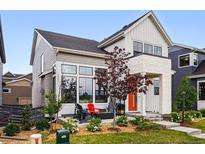 Charming home with an orange front door, covered porch, and well-manicured landscaping at 6237 Stable View St, Castle Pines, CO 80108