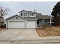 Two-story house with gray siding, two-car garage, and landscaping at 2193 S Waco St, Aurora, CO 80013