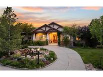 Stunning home featuring a well-manicured lawn, beautiful landscaping, and a charming water feature at 422 Suffolk Ln, Castle Rock, CO 80108