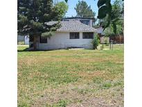 A single-story home features white siding and a well-maintained lawn at 256 S 2Nd Ave, Brighton, CO 80601
