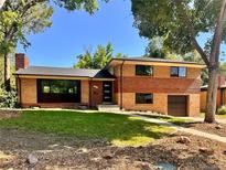 Lovely two-story brick home with mature trees, manicured lawn, and inviting front entrance in a desirable neighborhood at 9025 W 4Th Ave, Lakewood, CO 80226