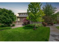 Well-manicured backyard featuring lush green grass, landscaping and mature trees in a private setting at 18112 E 104Th Way, Commerce City, CO 80022