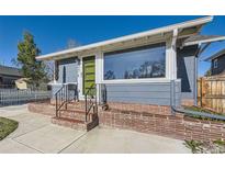Charming home entrance with a modern, lime green door, brick accents, and large window showcasing natural light at 4441 N Meade St, Denver, CO 80211