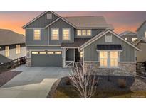 Charming two-story home with stone accents, gray siding and an attached two car garage at 5072 Lake Port Ave, Firestone, CO 80504