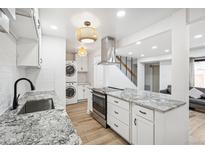 Bright kitchen featuring stainless appliances, granite countertops, and convenient washer/dryer hookups at 7995 E Mississippi Ave # A4, Denver, CO 80247