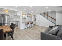 Open-concept living room features modern decor, breakfast bar, and staircase at 7995 E Mississippi Ave # A4, Denver, CO 80247