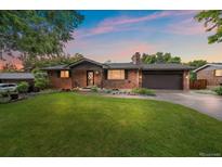 Charming brick home with a well-manicured lawn and a two-car garage offers great curb appeal at 7077 Dudley Dr, Arvada, CO 80004