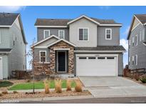 Charming two-story home with stone accents, well-kept lawn and a two car garage at 15076 W 93Rd Ave, Arvada, CO 80007