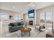 Bright living room features a fireplace, neutral decor, and comfortable seating at 15475 Andrews Dr # 412, Denver, CO 80239