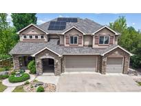 Beautiful two-story home featuring a stone and stucco facade, three-car garage, and solar panels at 5448 El Diente St, Golden, CO 80403