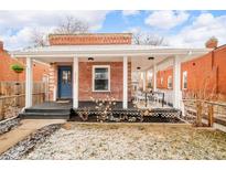 Charming brick home featuring a covered front porch, perfect for outdoor seating and relaxation at 2992 Hooker St, Denver, CO 80211