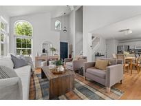 Bright living room with vaulted ceilings, oversized windows, hardwood floors, and stylish furnishings at 1359 S Beeler Ct, Denver, CO 80247