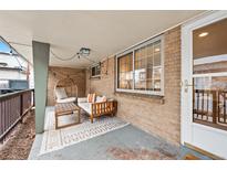 Cozy covered porch featuring a unique egg chair, stylish seating, and a patterned rug on the floor at 2461 Yates St, Denver, CO 80212