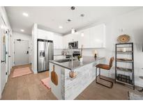 Modern kitchen featuring stainless steel appliances, gray countertops and an island with breakfast bar at 1898 S Bannock St # 202, Denver, CO 80223