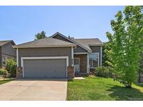 Charming single-Gathering home featuring a well-kept lawn, attached garage, and inviting brick accents at 19688 E Lasalle Dr, Aurora, CO 80013