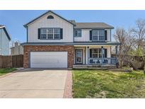 Charming two-story home featuring a brick-accented facade, inviting front porch, and well-maintained lawn at 9456 Bexley Dr, Highlands Ranch, CO 80126